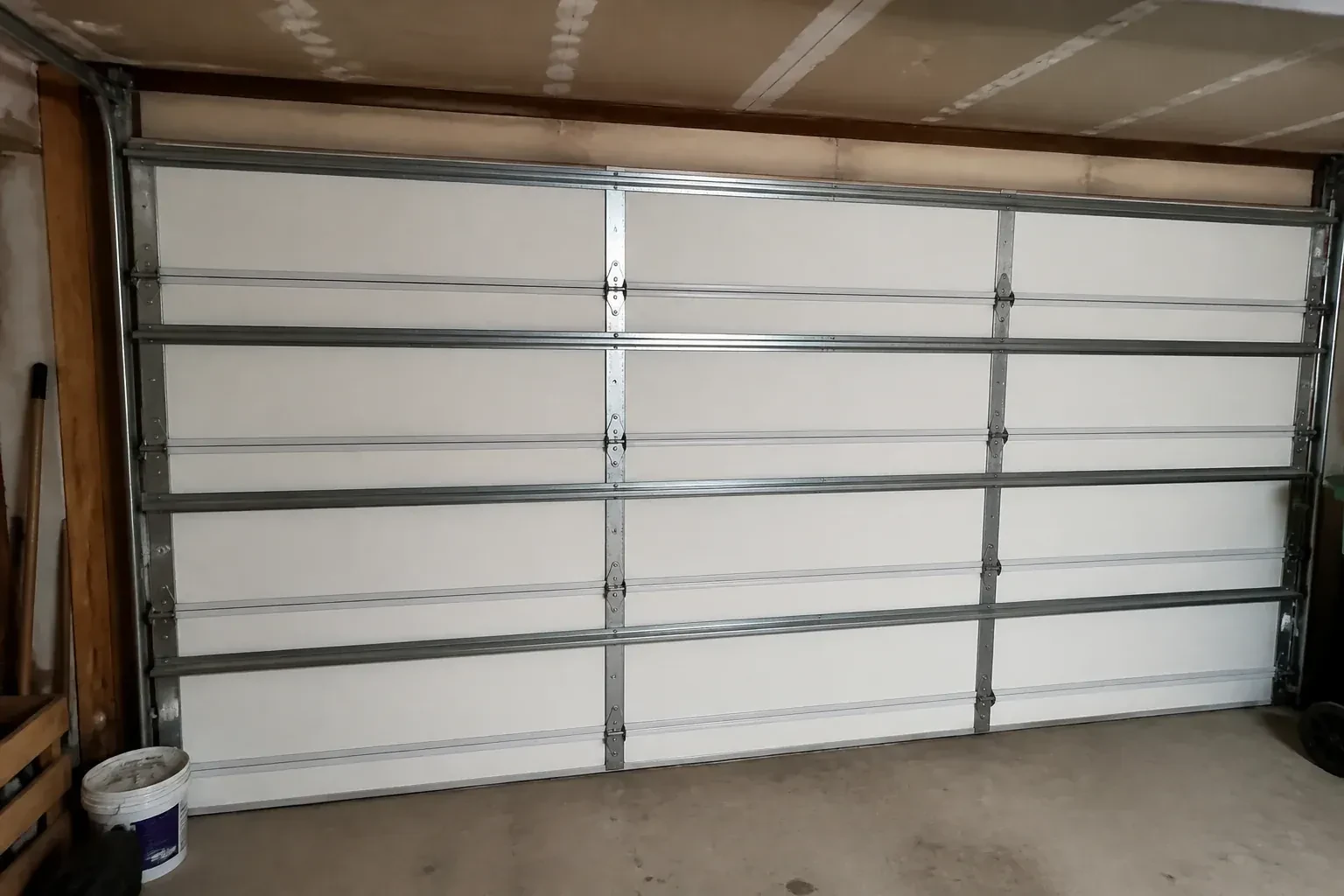 Interior of a closed sectional door with horizontal metal reinforcement struts. — Wind-Rated Garage Door Replacement, Peterborough